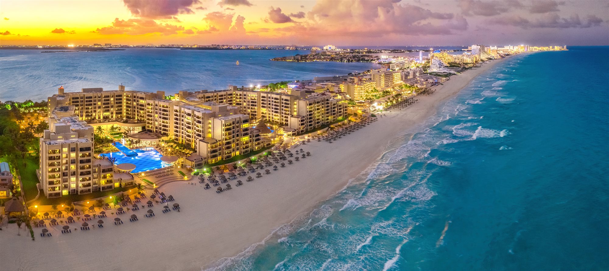 All-inclusive beach resort with pool at sunset